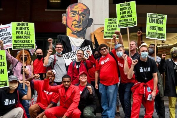 Workers united in a labor union rally holding signs for fair wages and rights.